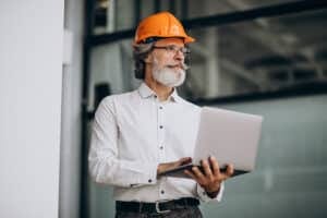 man in a hardhat holding a laptop